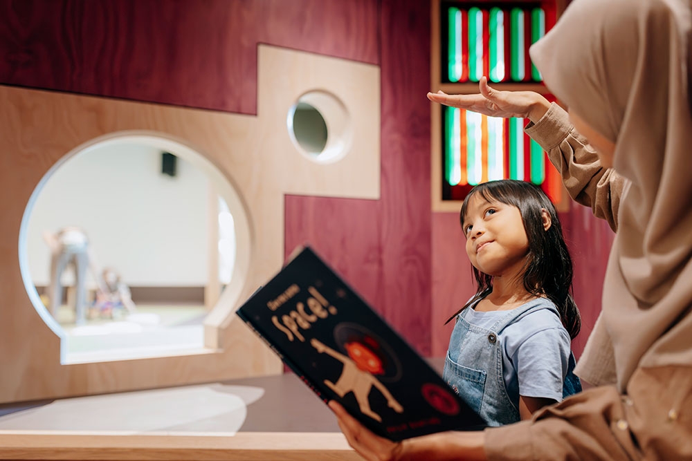 Child reading book in The Corner
