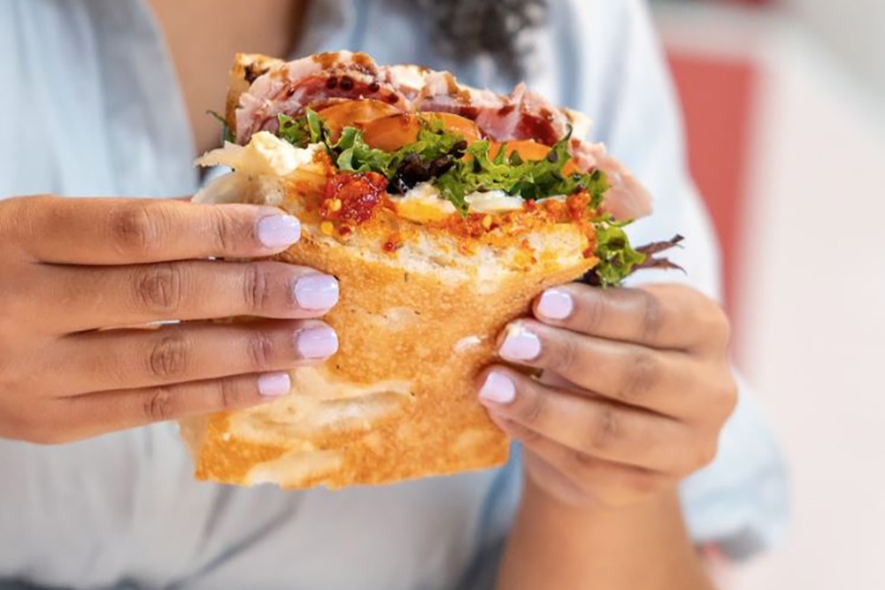 Gill holding sandwich at Sandwich Studio Carindale