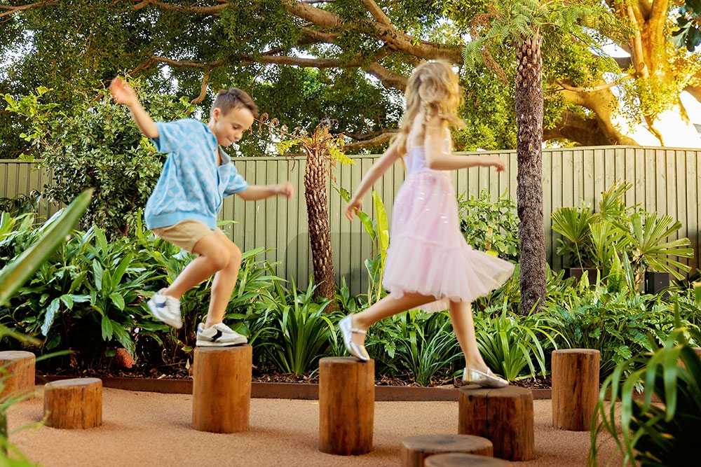 Kids walking on logs The Secret Garden South City Square