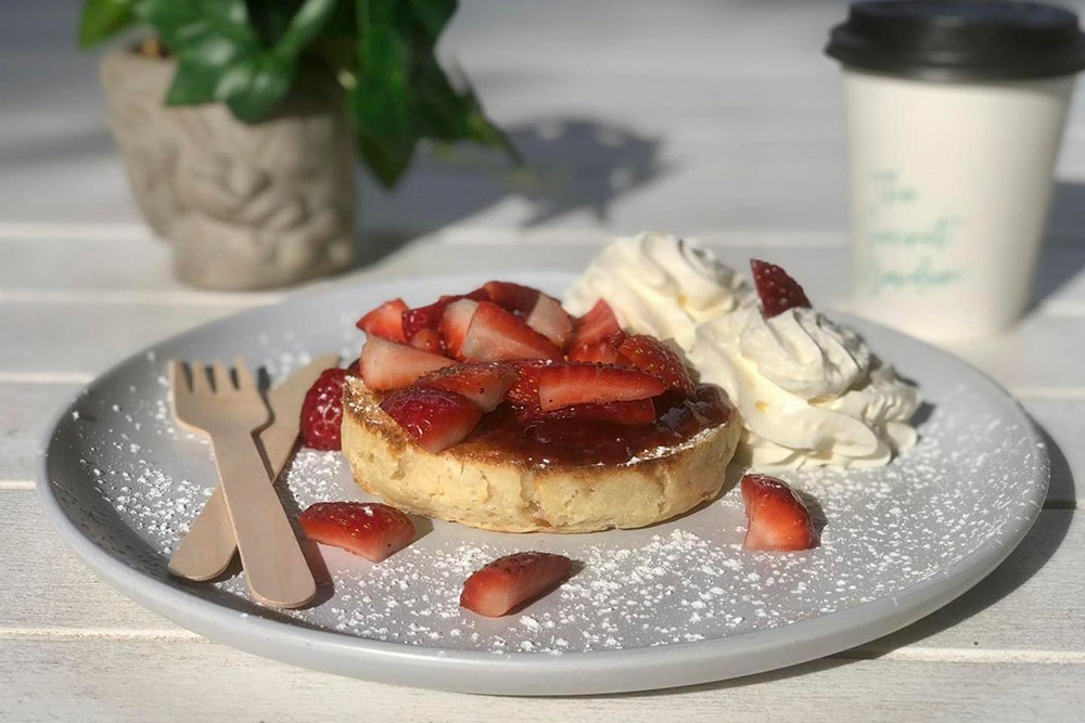 Crumpet on plate with berries and cream