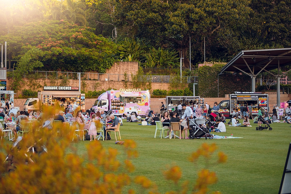 People and food trucks on lawn