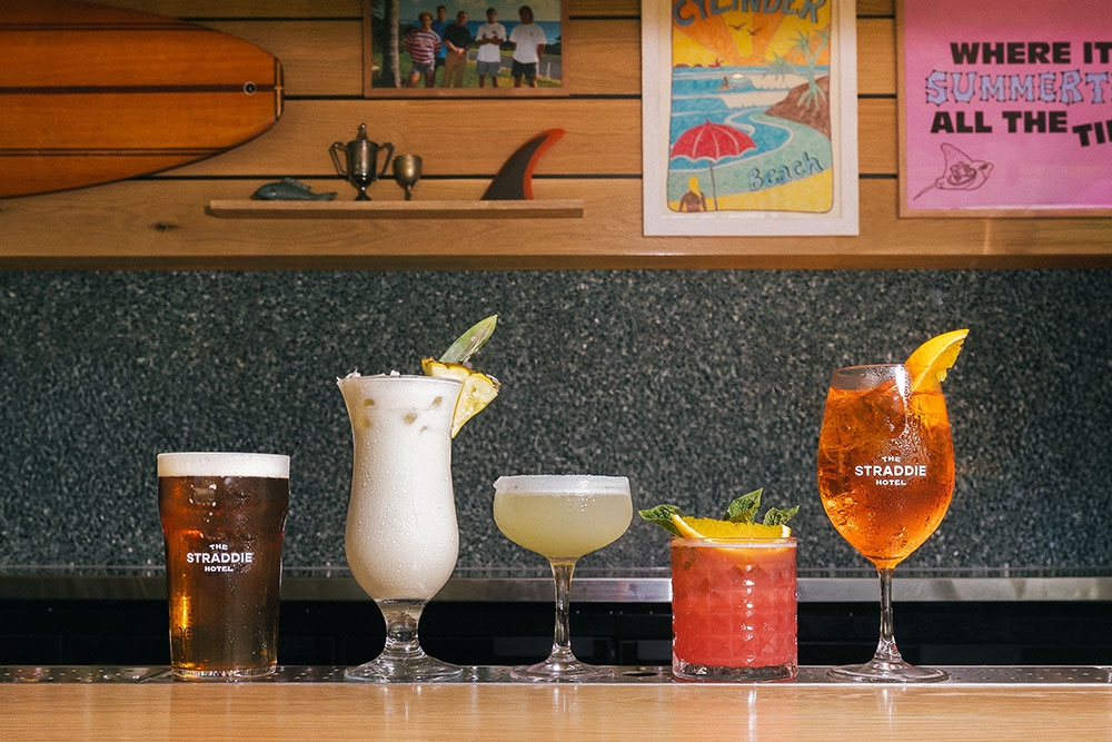 Glasses of beer and cocktails linked up on the bar at The Straddie Hotel, North Stradbroke Island