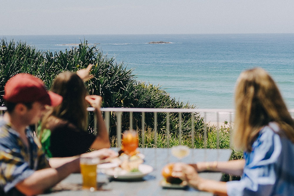 People sitting outside on the deck at The Straddie Hotel, North Stradbroke Island