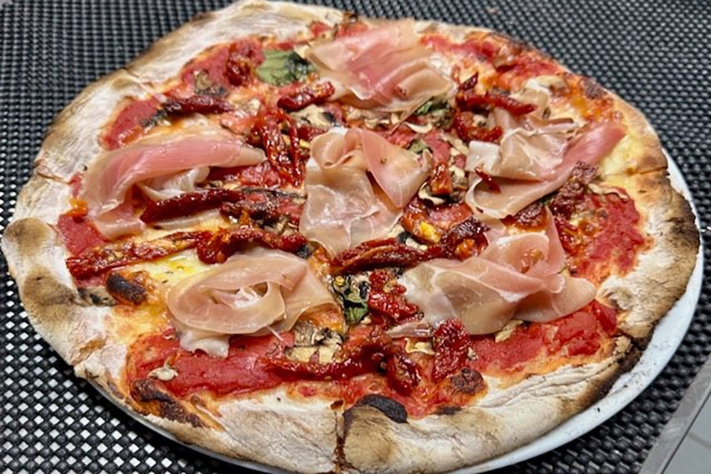 Pizza on serving dish at Trenino Trattoria