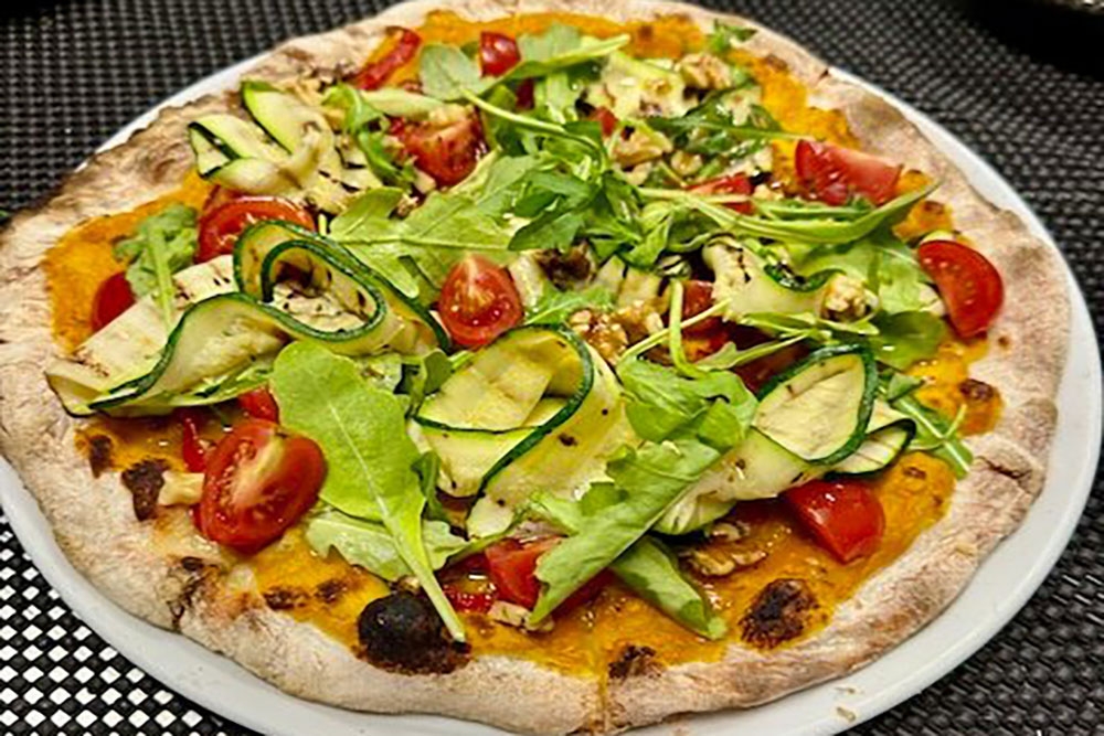 Vegana pizza on plate at Trenino Trattoria 