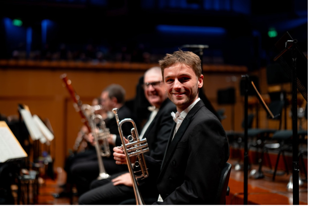 man sitting and smiling with instrument 