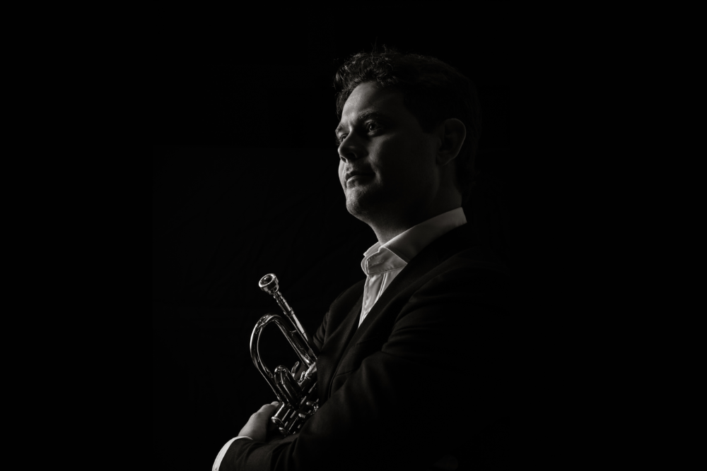 Man in black and white holding trumpet 