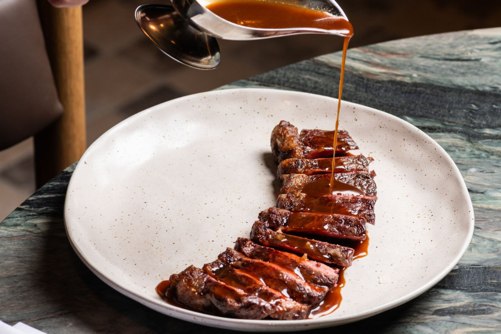 Steak with gravy being poured over it 