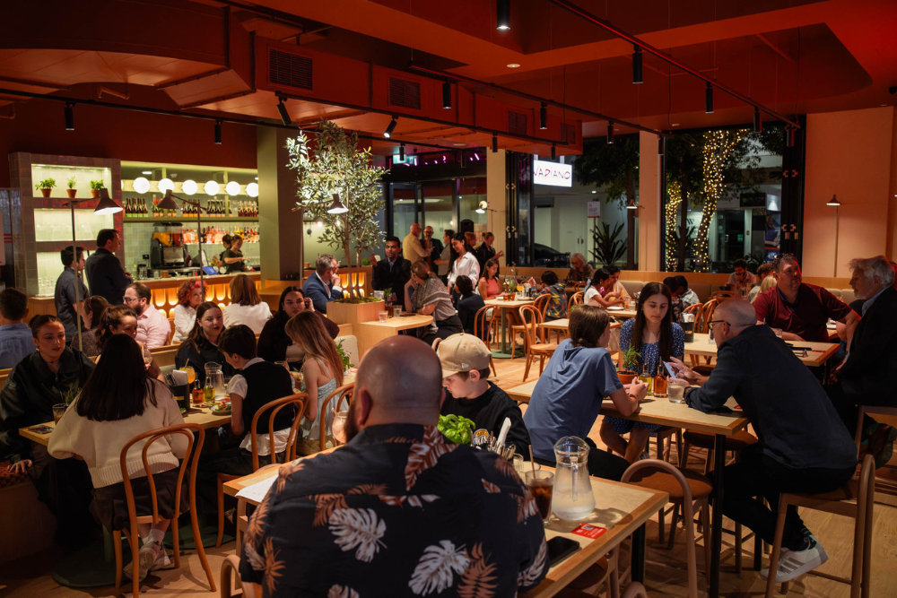 People dining at night inside Vapiano Italian Restaurant, Ipswich