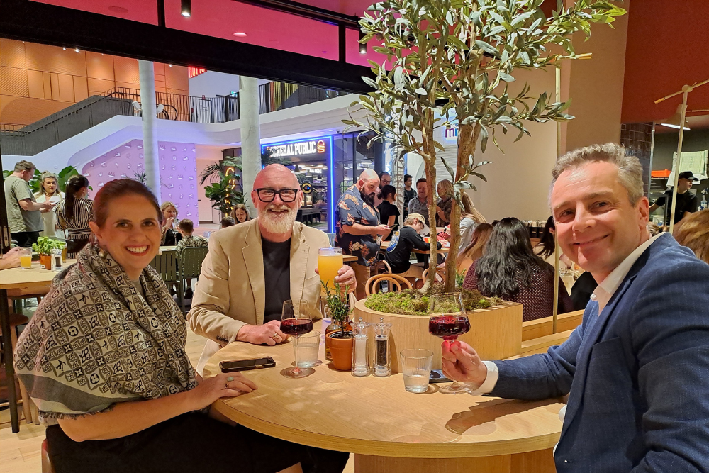 Three people dining at night inside Vapiano Italian Restaurant, Ipswich