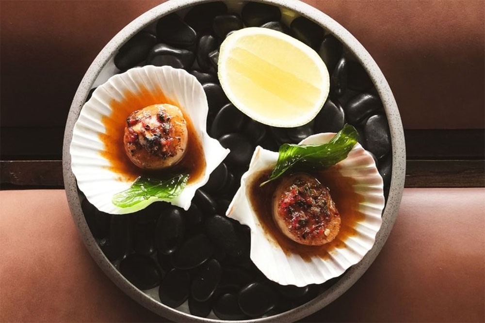 Baked scallops with chilli jam, butter and basil at Vela Kinn West End