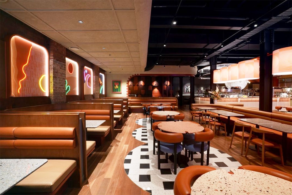 Booths and tables and chairs inside Vela Kinn West End