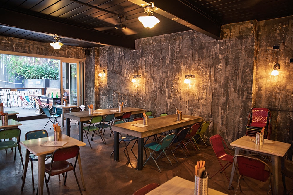 Lit up side wll and tables inside Warisan Indonesian restaurant