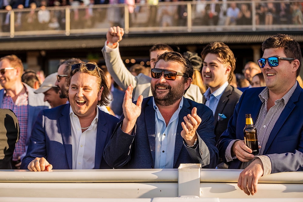 Men cheering behind a barrier at the Stradbroke Season 2026 races