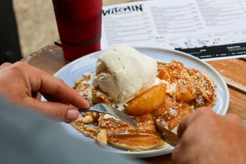 A man using a knife and fork to eat his breakfast