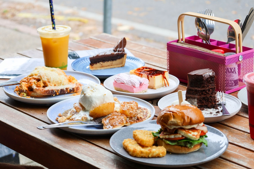 Multiple plates of food and drinks sitting on a table
