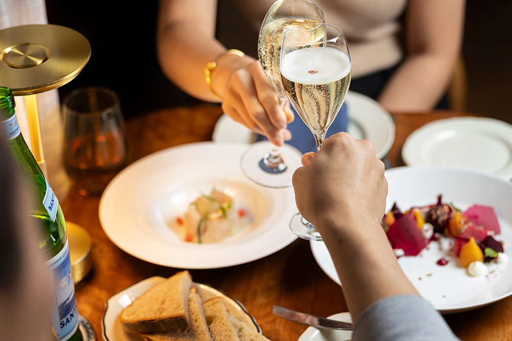 Plates of food and two people with glasses of champagne