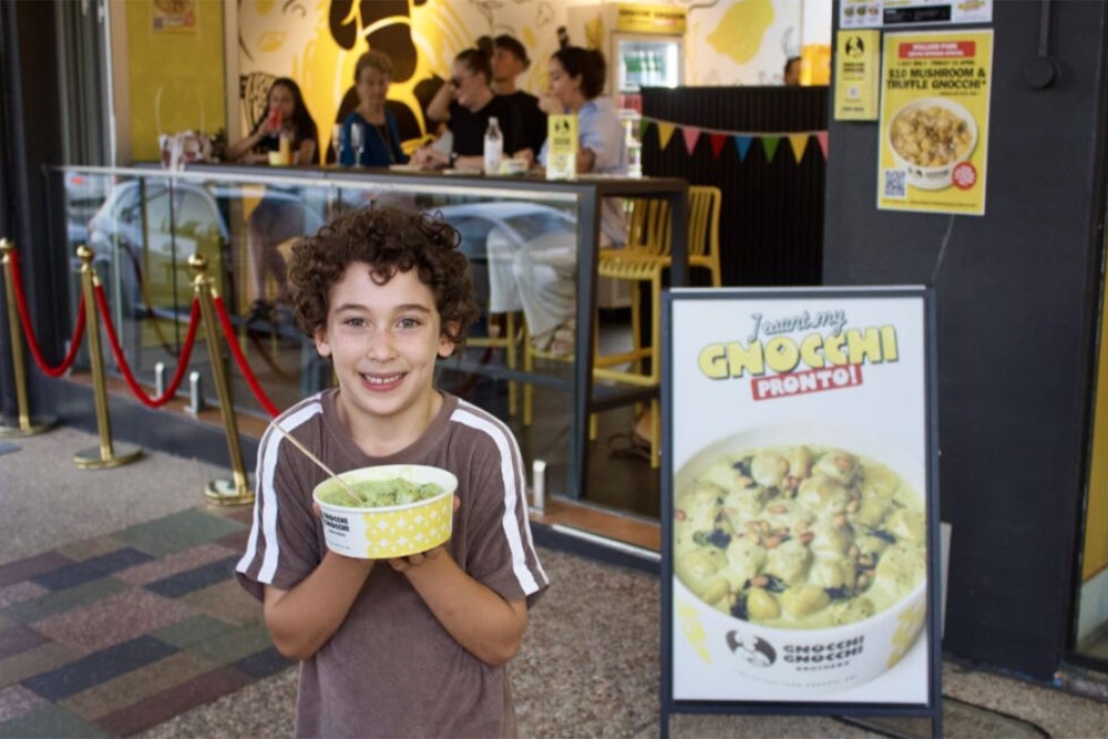 Kid with bowl of gnocchi outside Gnocchi Gnocchi Brothers