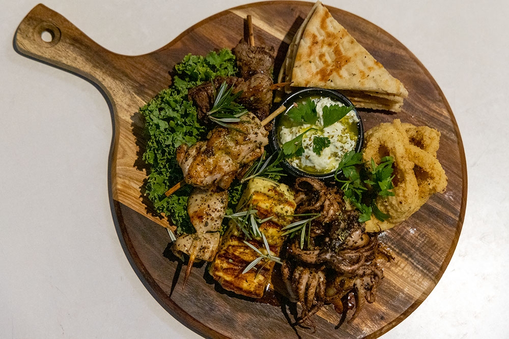 Greek food on a wooden board at Lefkas Taverna