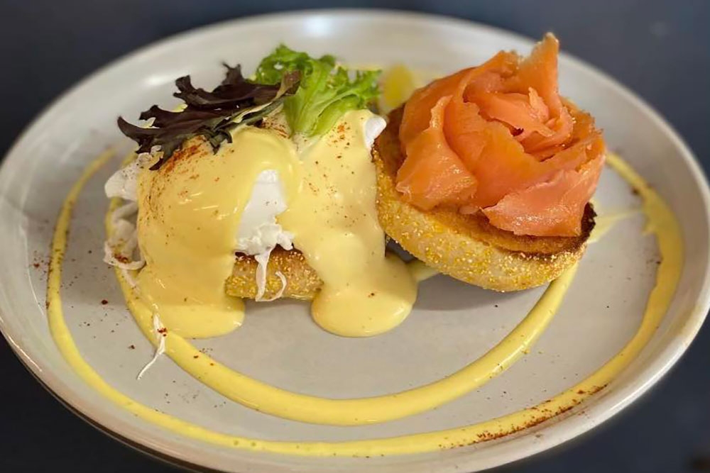 Eggs Benedict on a plate with smoked salmon at The LoveWell Project Cafe Mt Gravatt Lookout