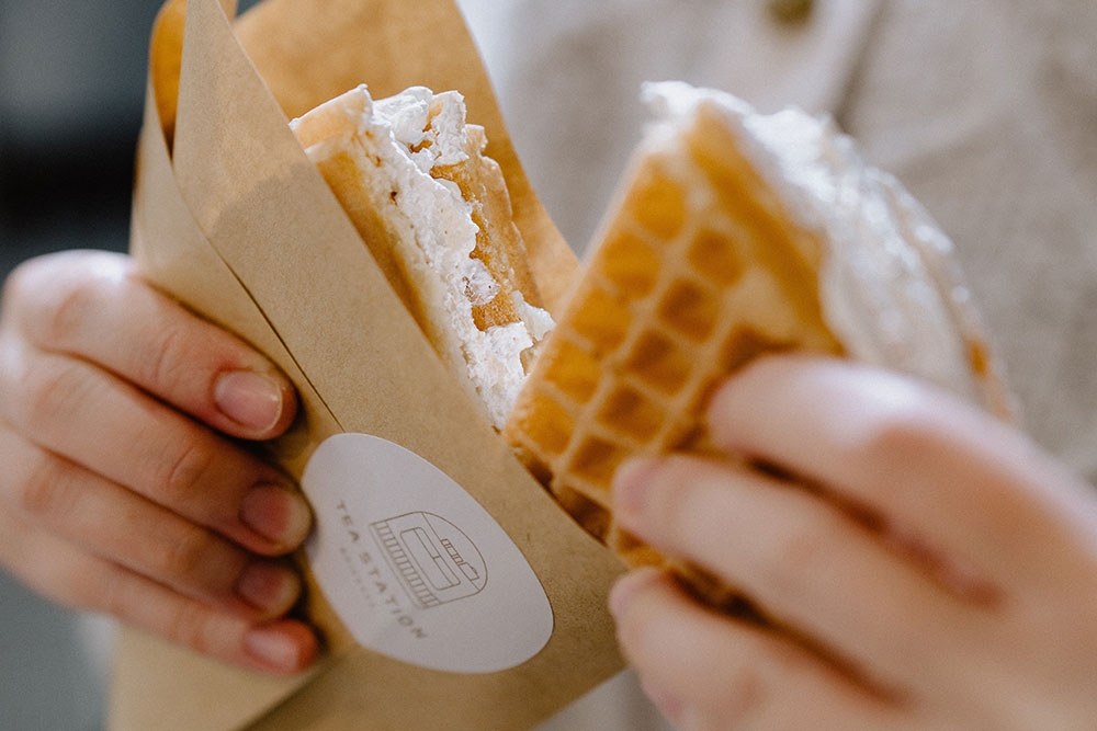 Hands breaking apart a Korean waffle at the Tea Station Eight Mile Plains