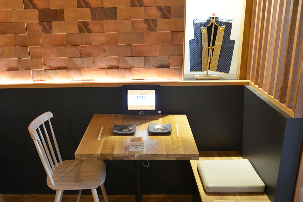 Table and chairs inside Okuman Karaage & Ramen Bar West End