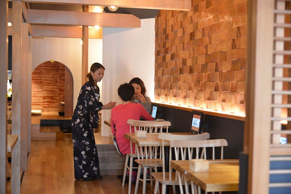 Diners with komono clad wait staff at Okuman Karaage & Ramen Bar West End