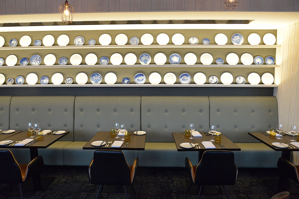 Tables with commemorative plates on the back wall at Six Acres Restaurant Bowen Hills
