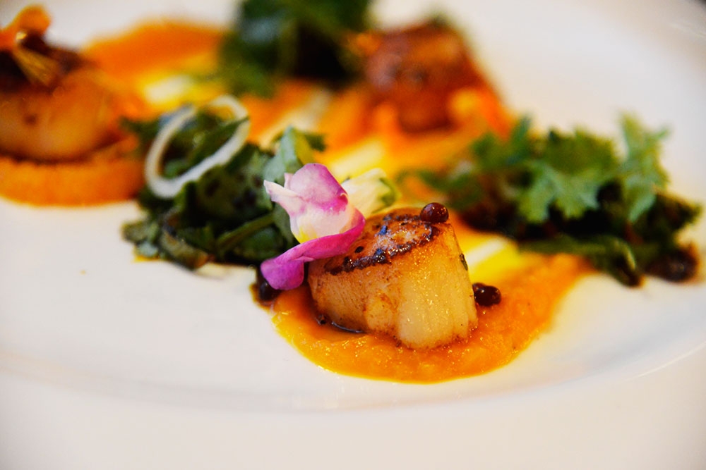 Food on a plate with flower garnish at Six Acres Restaurant Bowen Hills