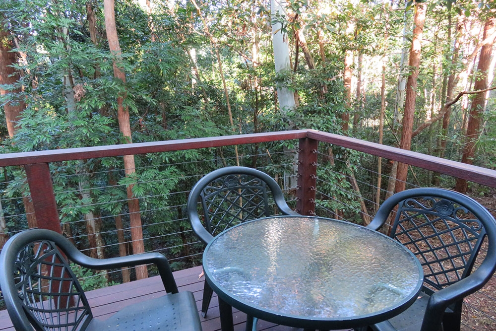 Tables and chairs on a deck overlooking bush