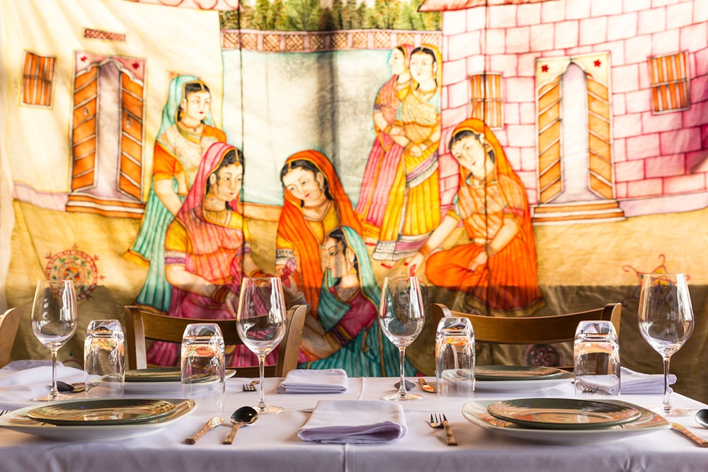 Table set for dinner at It's Mirchi Paddington with mural on wall in background