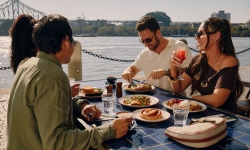 People eating breakfast with story bridge in the background Dine BNE City