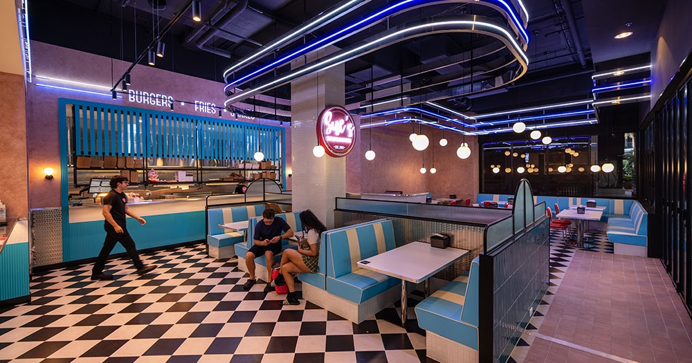 Two people sitting on a booth inside Sue's Burgers and Shakes Woolloongabba